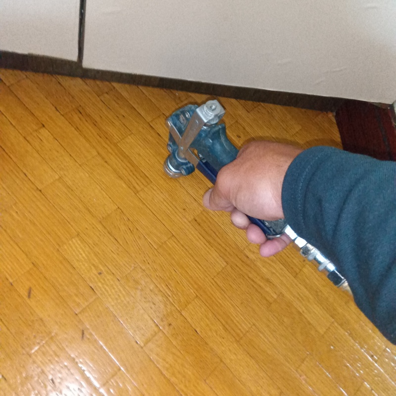 キッチンの床にシロアリ駆除剤を注入する様子