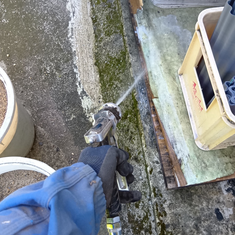 基礎まわりにシロアリ駆除剤を散布する様子