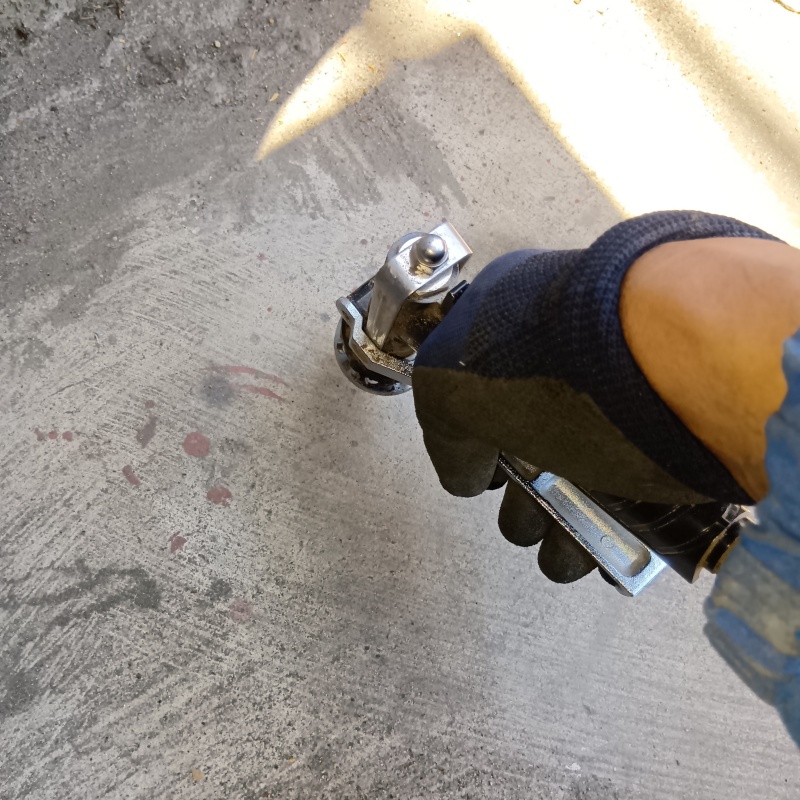 玄関の床にシロアリ駆除剤を注入する様子