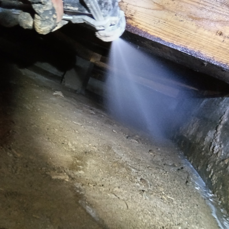 床下の土壌にシロアリ駆除剤を散布する様子