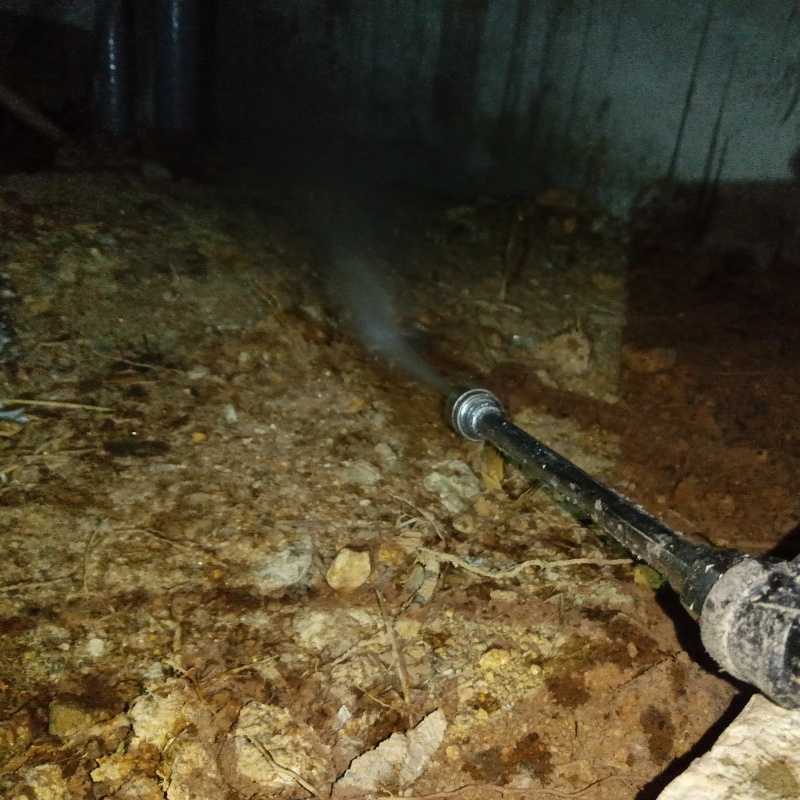 床下の土壌に防蟻剤を散布する様子