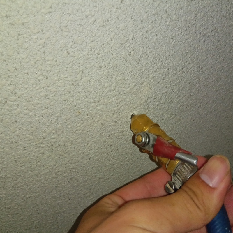 洗面所の壁に防蟻剤を注入する様子