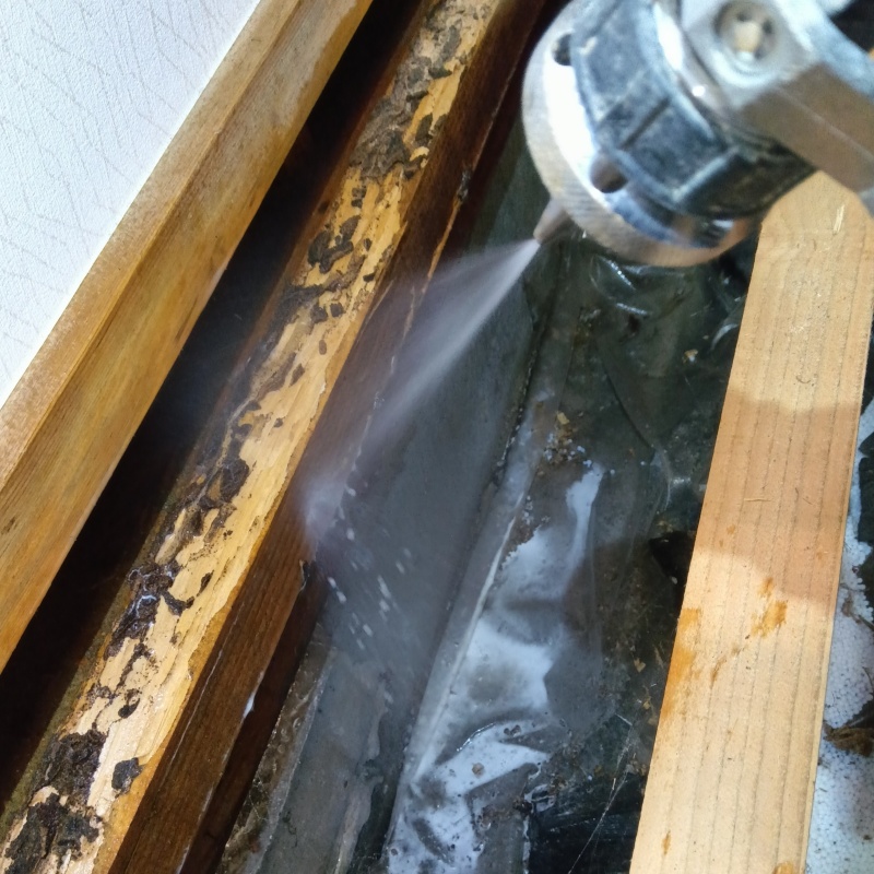 床下の木材にシロアリ駆除剤を散布する様子