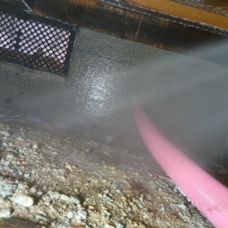 床下の土壌にシロアリ駆除剤を散布する様子