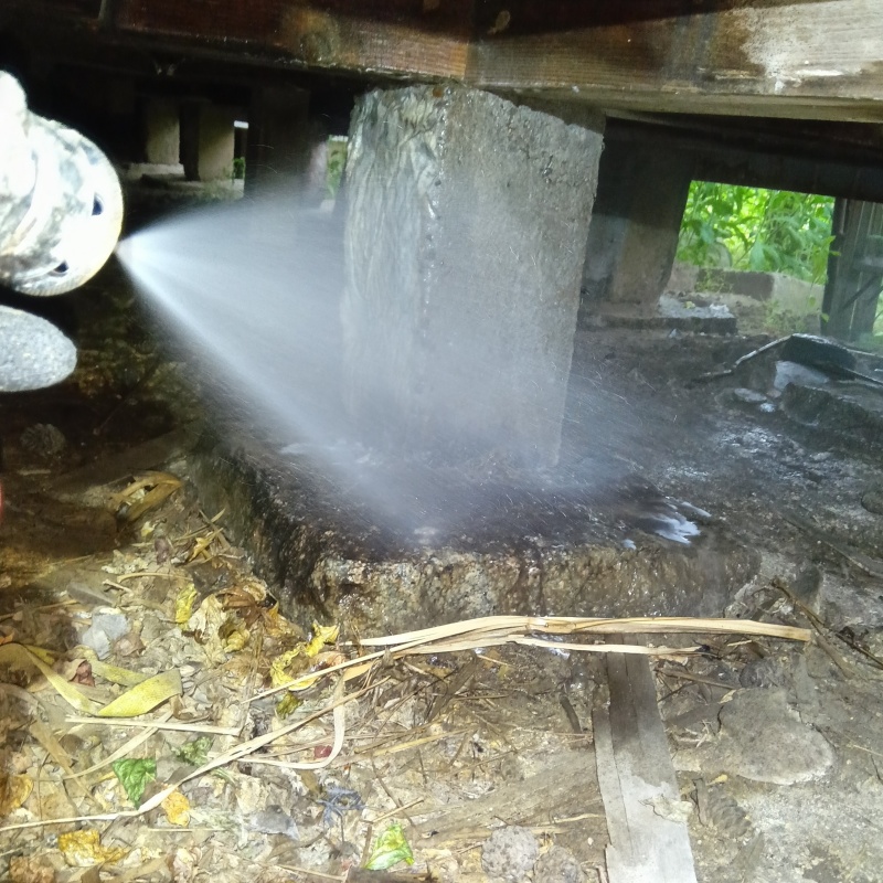 床下の基礎部分にシロアリ駆除剤を散布する様子