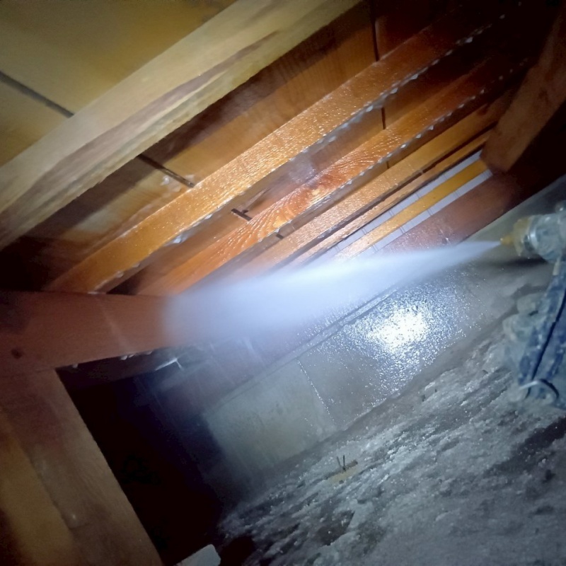 床下の木材にシロアリ駆除剤を散布する様子