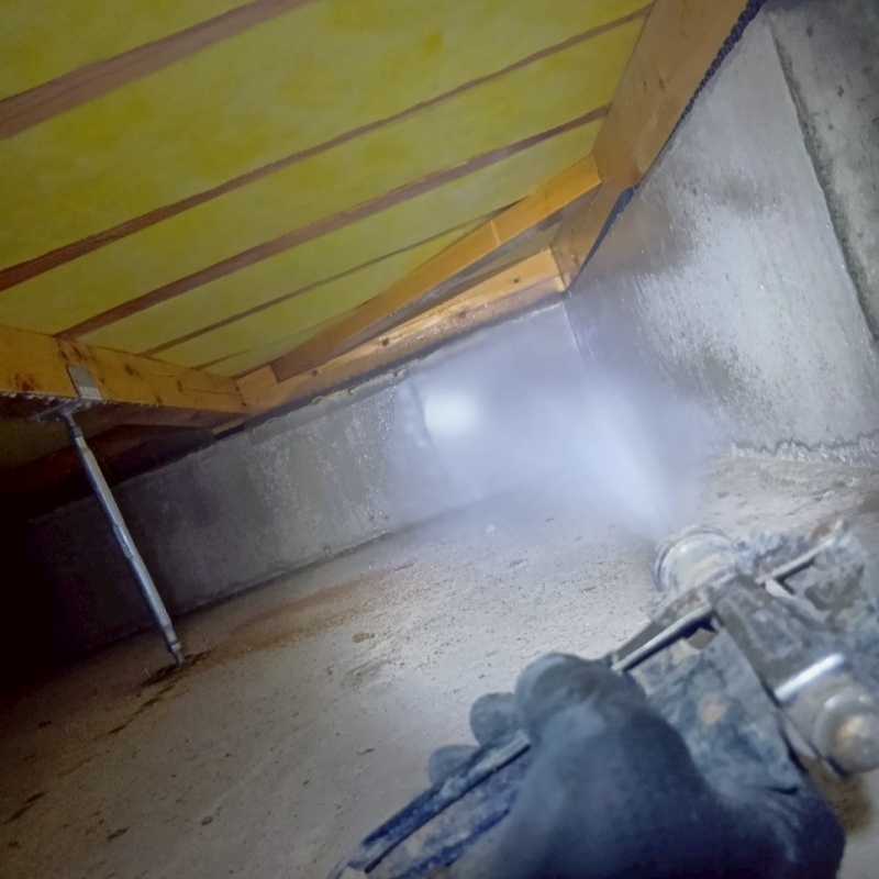 床下の基礎部分にシロアリ駆除剤を散布する様子