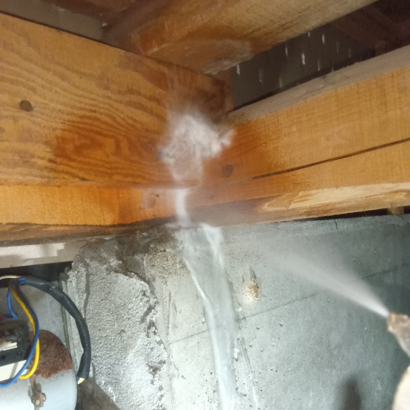床下の木材にシロアリ駆除剤を散布する様子