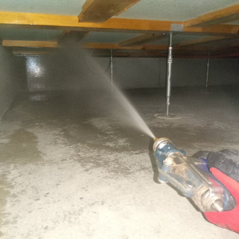 床下の木材に防蟻剤を散布する様子