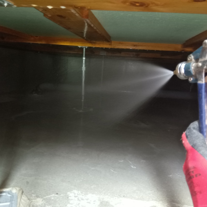 床下の土壌に防蟻剤を散布する様子