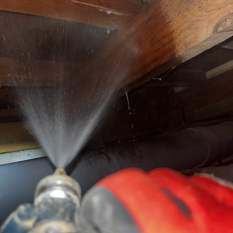 床下の木材にシロアリ駆除剤を散布する様子