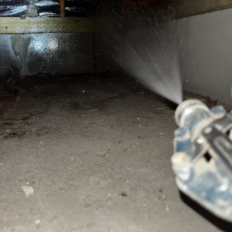 床下の基礎部分にシロアリ駆除剤を散布する様子