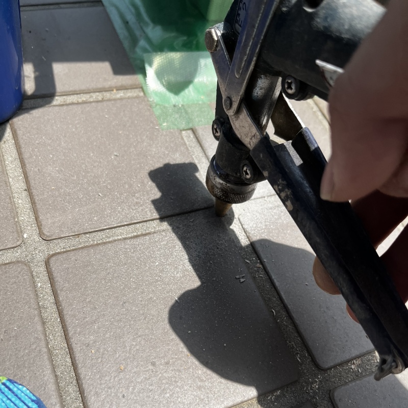 玄関の床にシロアリ駆除剤を注入する様子