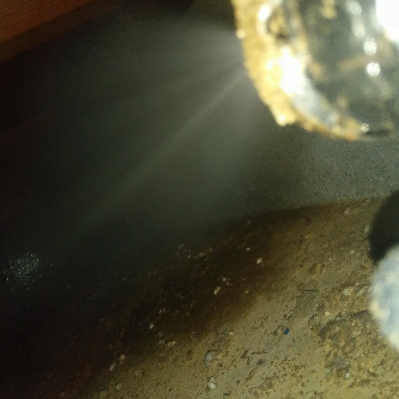 床下の土壌にシロアリ駆除剤を散布する様子