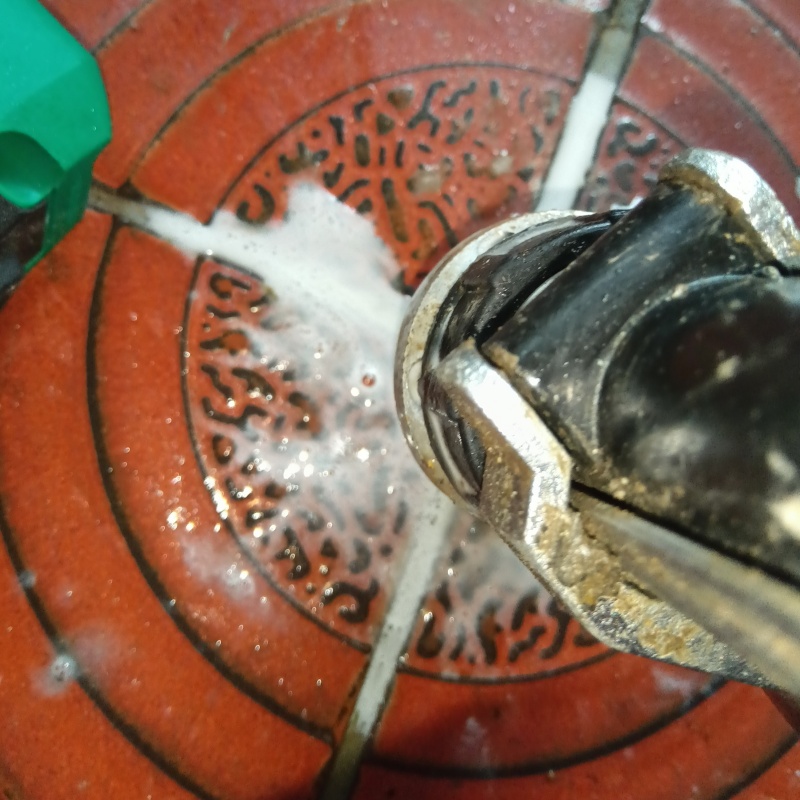 玄関の床にシロアリ駆除剤を注入する様子