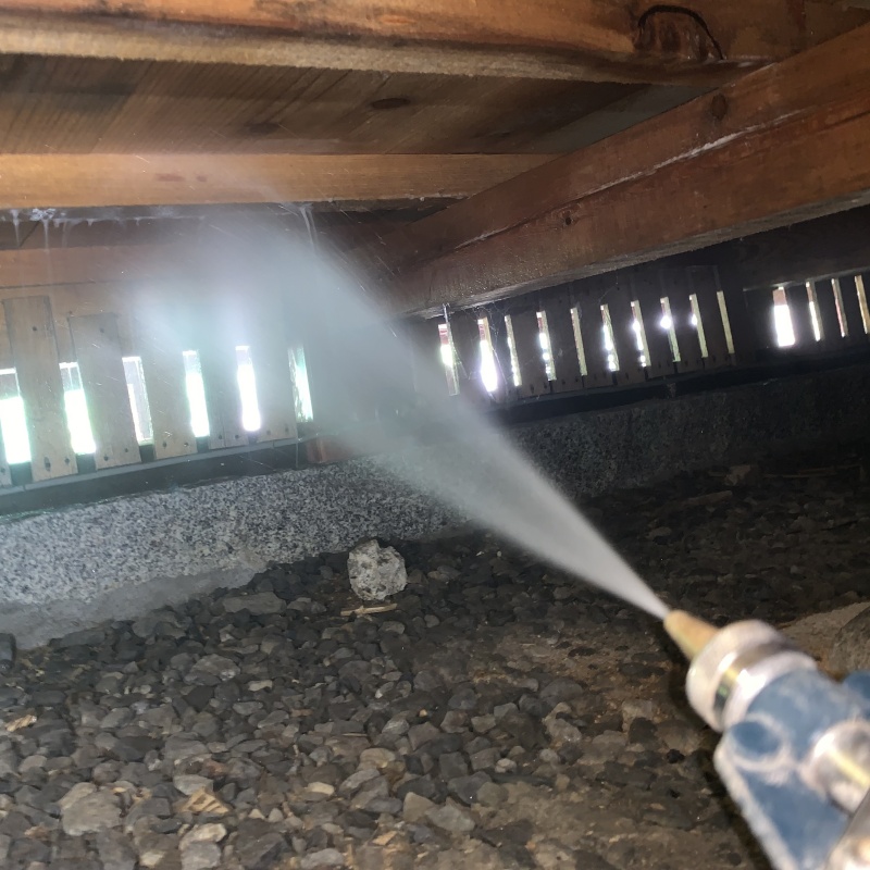 床下の木材にシロアリ駆除剤を散布する様子