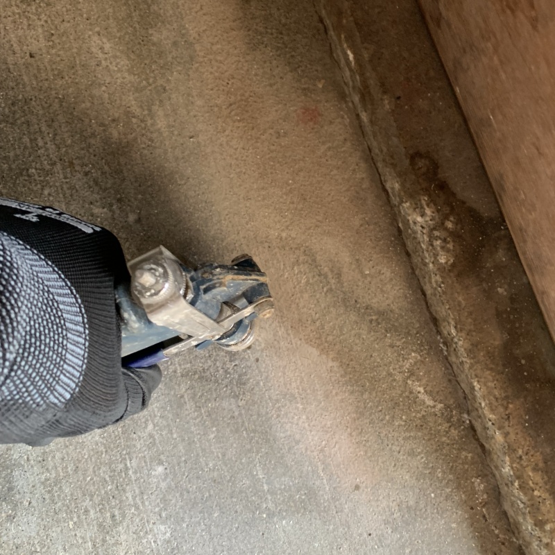 玄関の床にシロアリ駆除剤を注入する様子