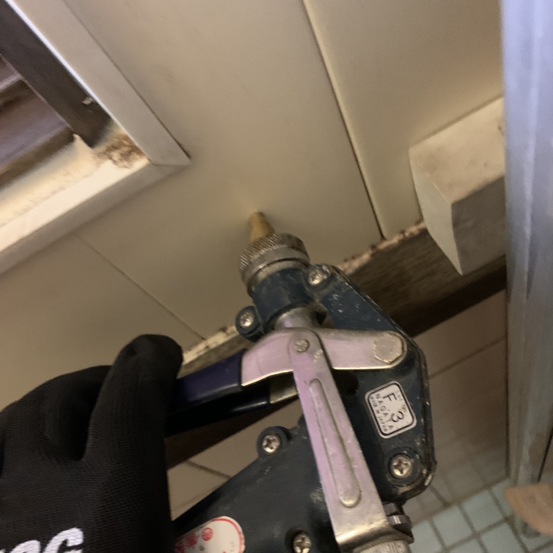 浴室の壁にシロアリ駆除剤を注入する様子