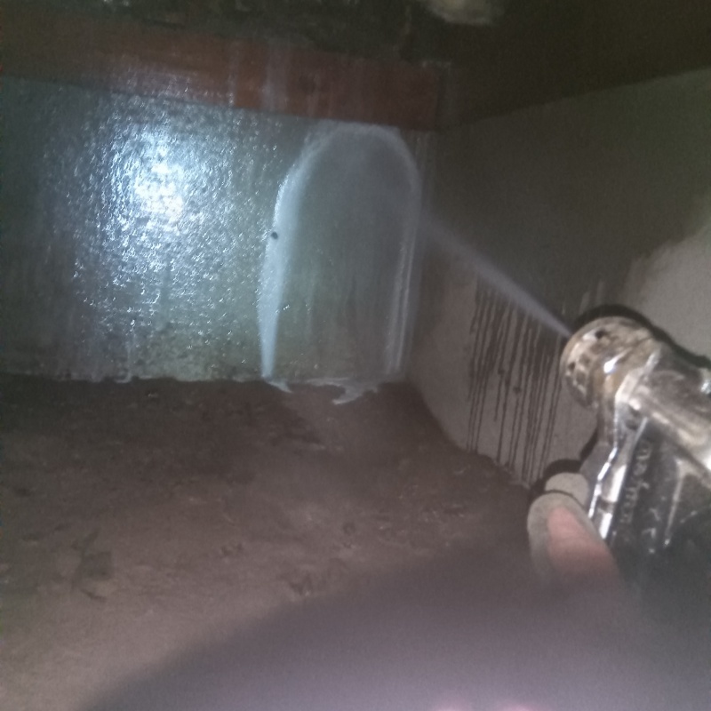床下の基礎部分にシロアリ駆除剤を散布する様子