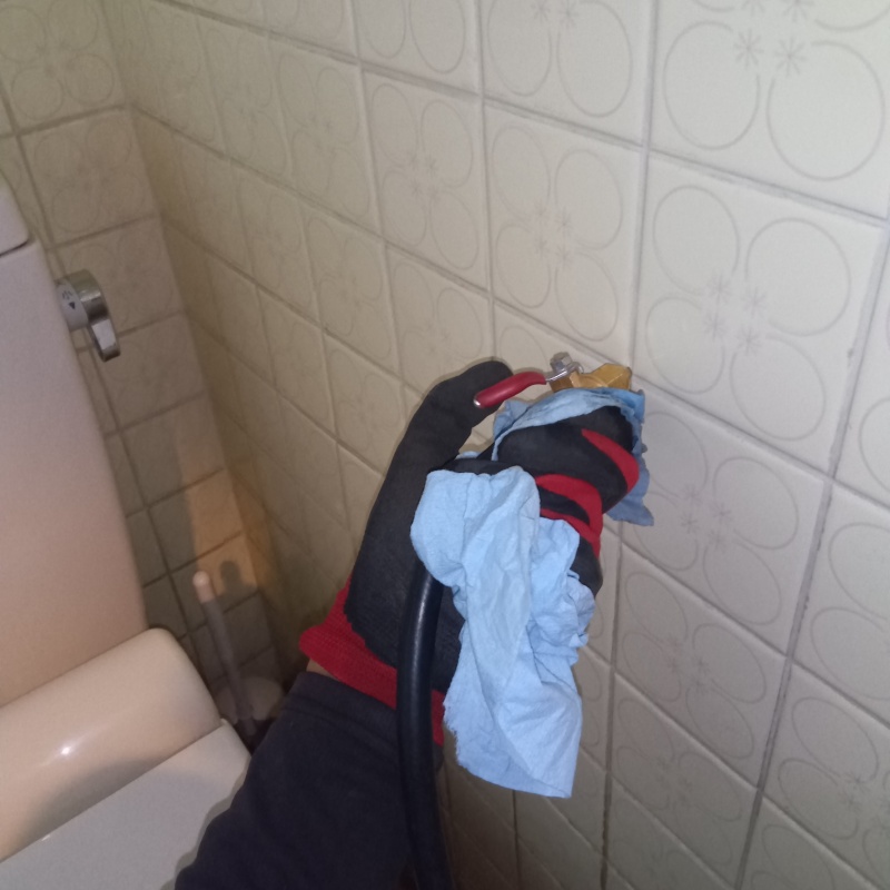 トイレの壁にシロアリ駆除剤を注入する様子