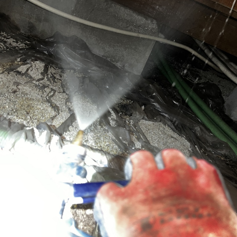 床下の土壌に防蟻剤を散布する様子