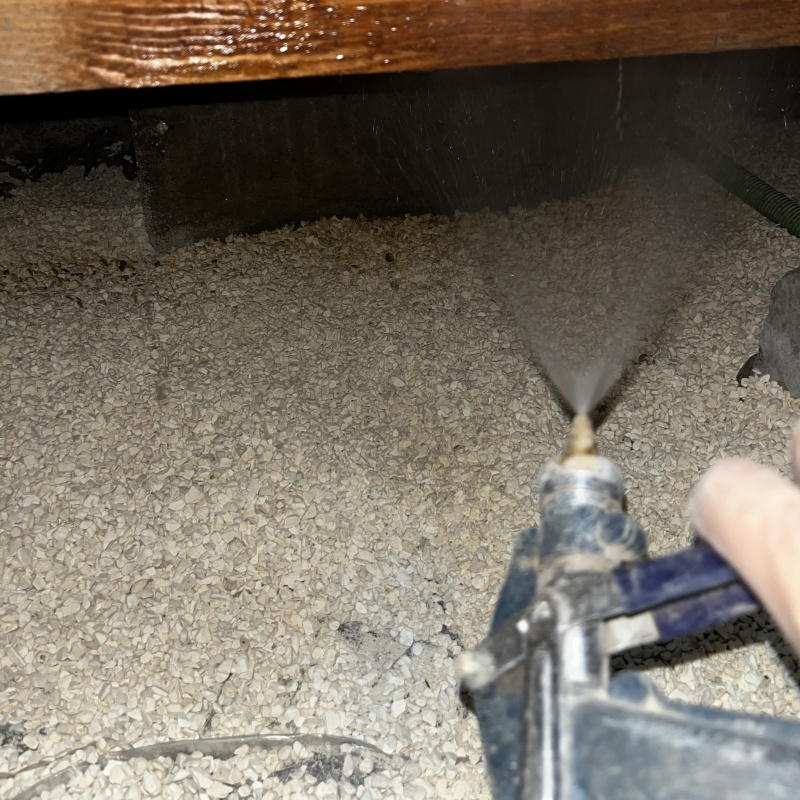 床下の土壌に防蟻剤を散布する様子