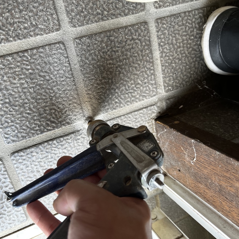 玄関の床に防蟻剤を注入する様子