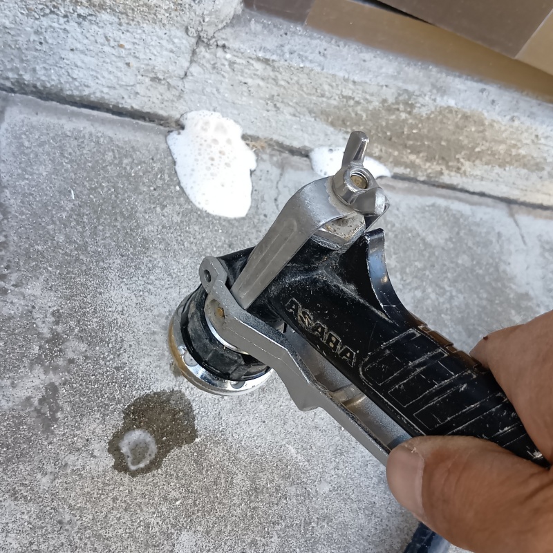 玄関の床にシロアリ駆除剤を注入する様子