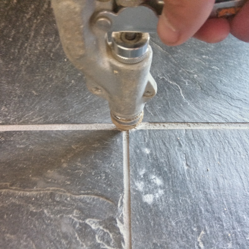 玄関の床に防蟻剤を注入する様子