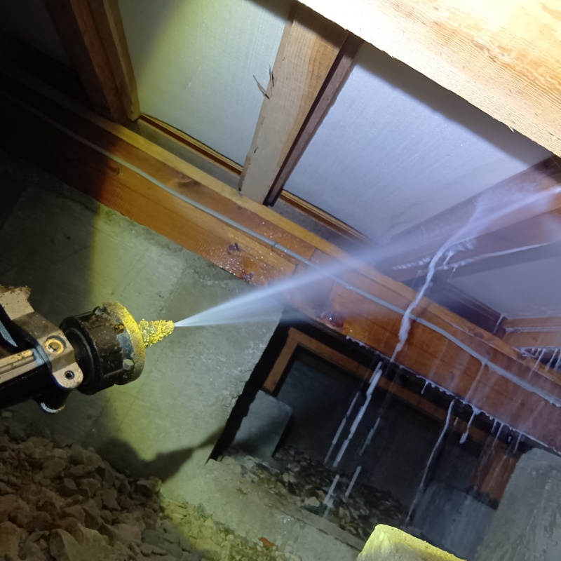 床下の木材にシロアリ駆除剤を散布する様子