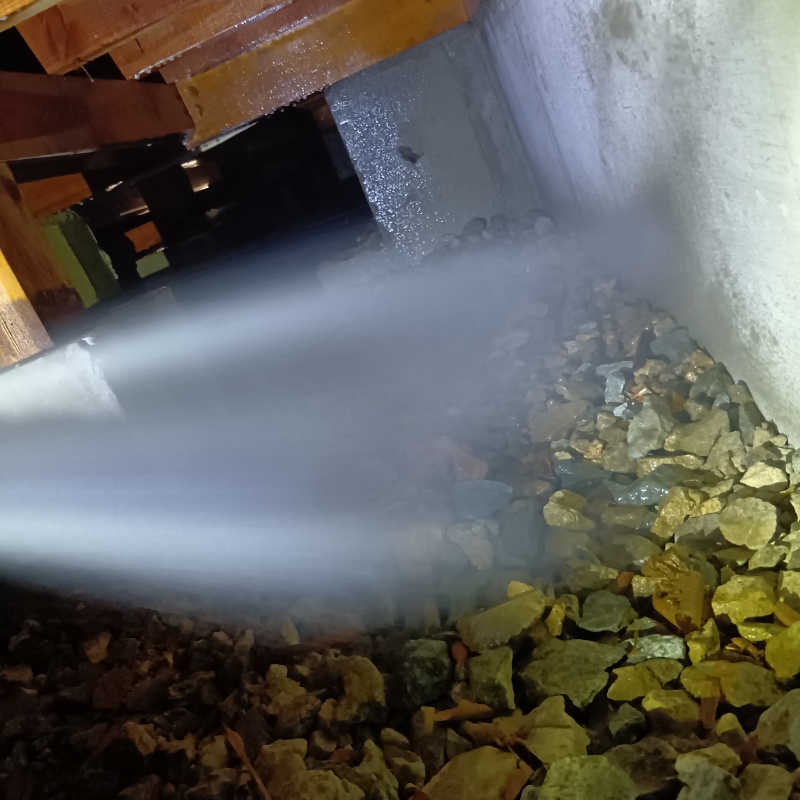 床下の土壌にシロアリ駆除剤を散布する様子
