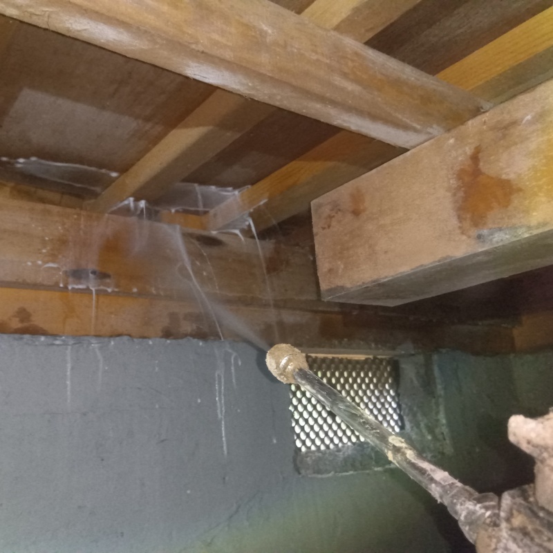 床下の木材にシロアリ駆除剤を散布する様子