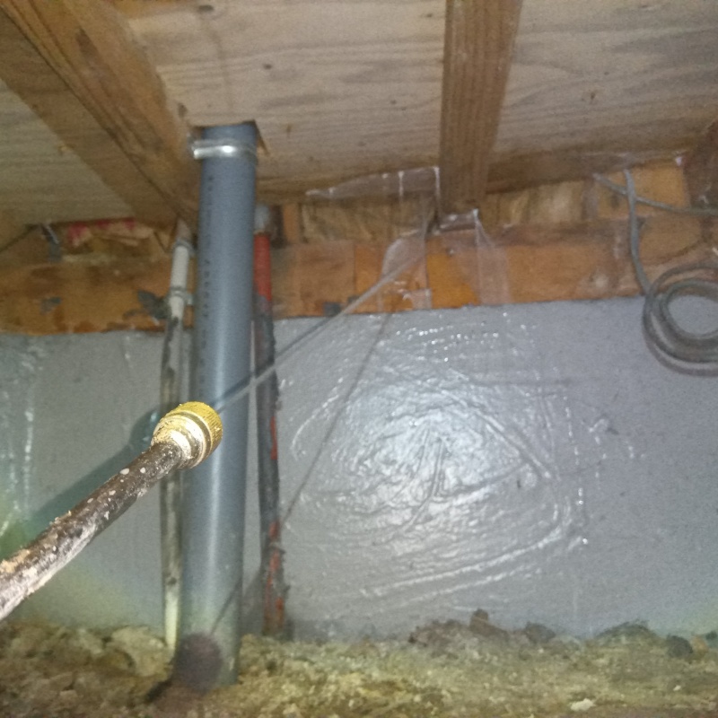 床下の木材にシロアリ駆除剤を散布する様子