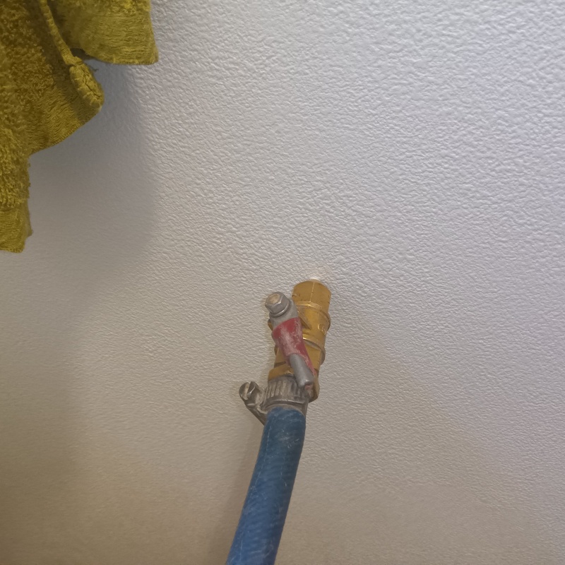 洗面所の壁にシロアリ駆除剤を注入する様子