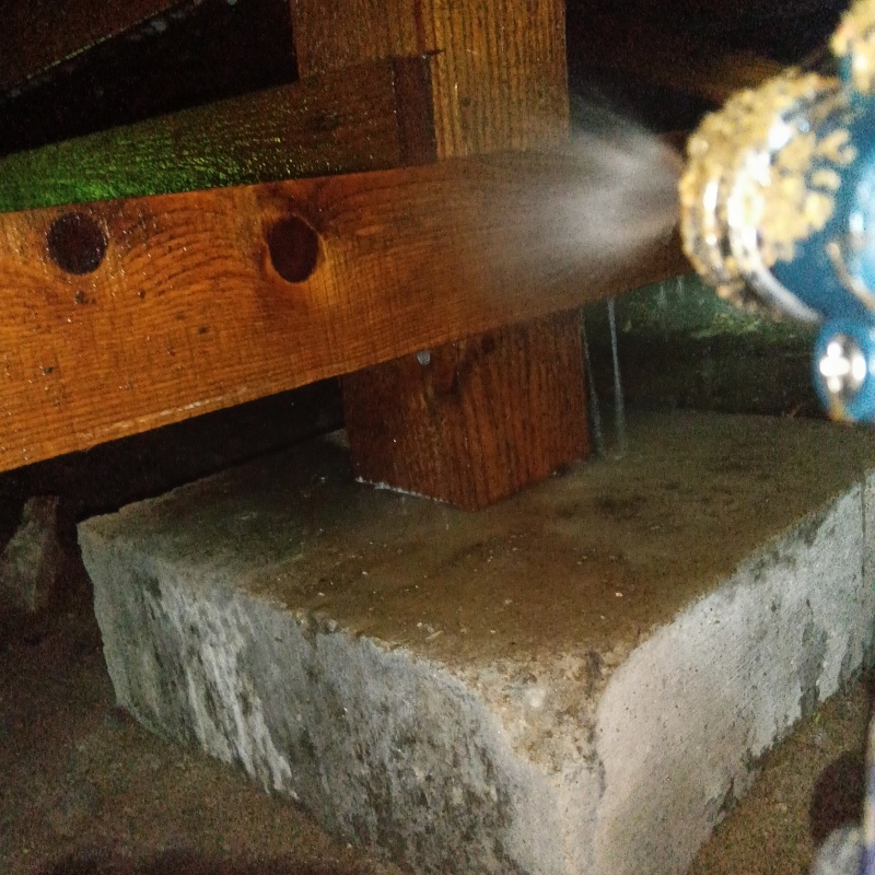 床下の木材にシロアリ駆除剤を散布する様子