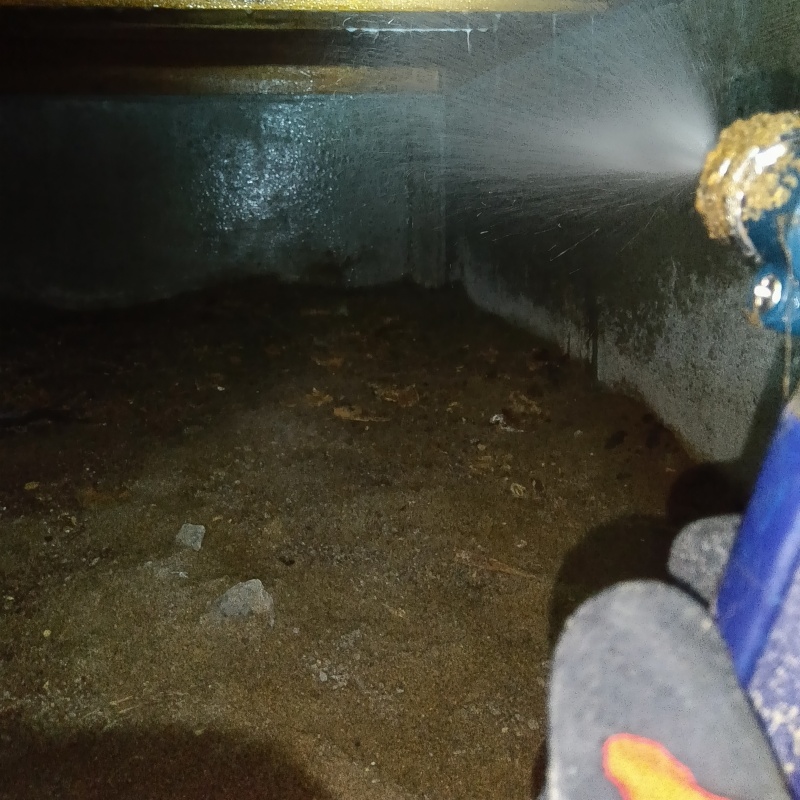 床下の基礎部分にシロアリ駆除剤を散布する様子