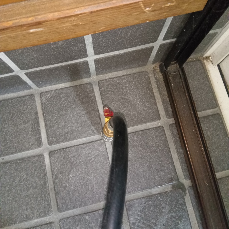 玄関の床にシロアリ駆除剤を注入する様子