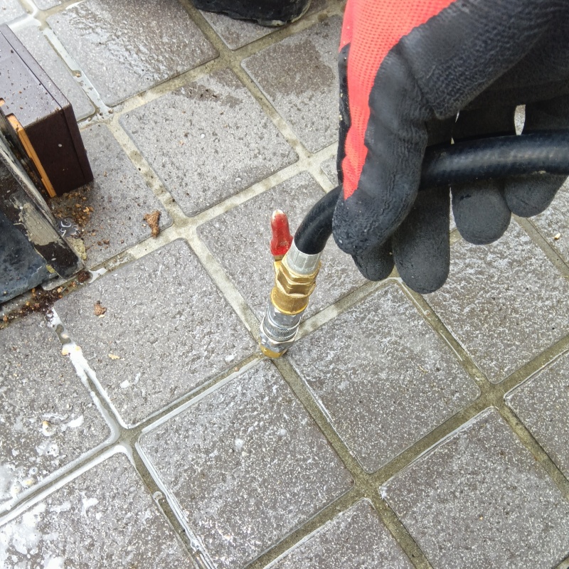 玄関の床にシロアリ駆除剤を注入する様子