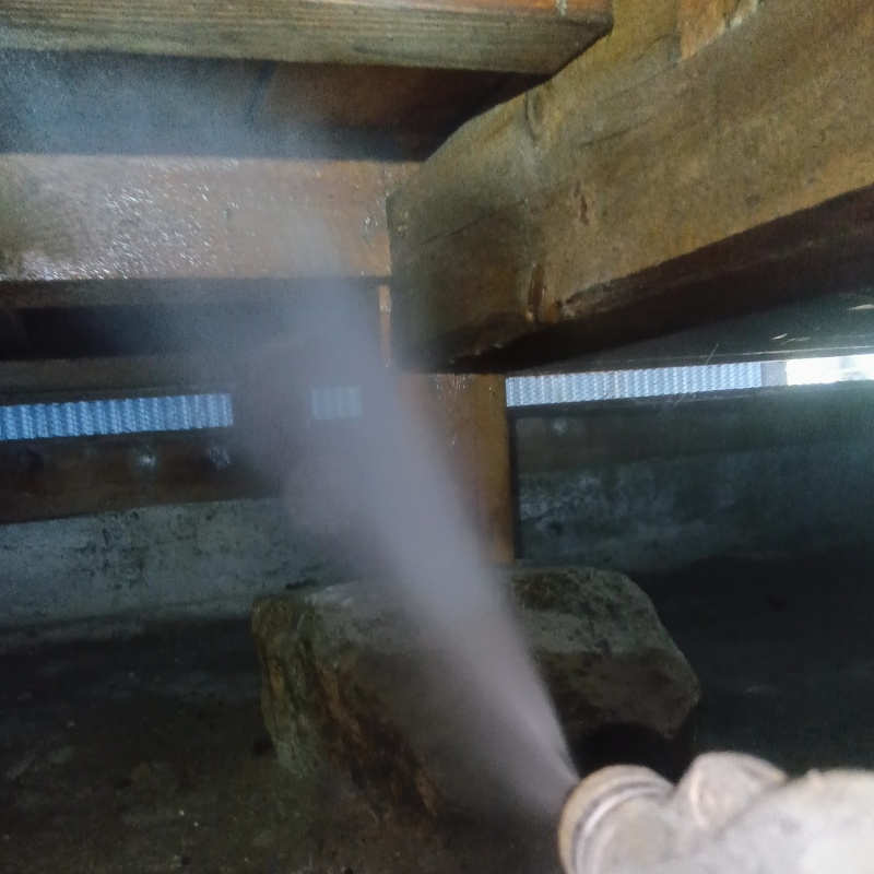 床下の木材にシロアリ駆除剤を散布する様子