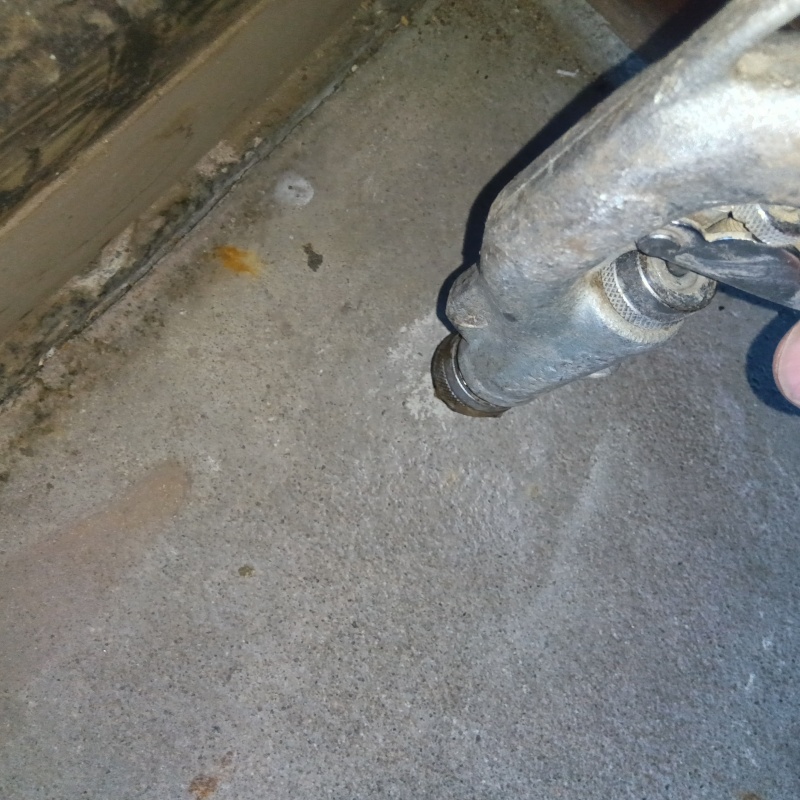 玄関の床にシロアリ駆除剤を注入する様子