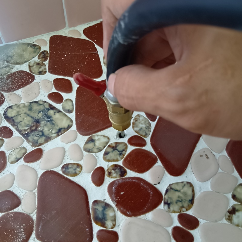 浴室の床にシロアリ駆除剤を注入する様子