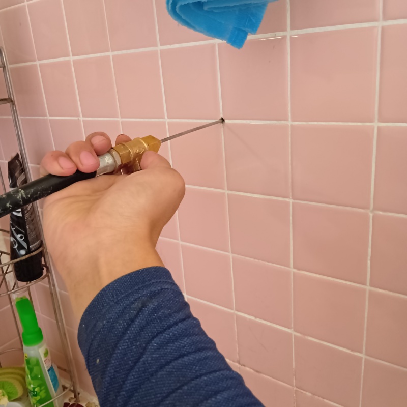 浴室の壁にシロアリ駆除剤を注入する様子