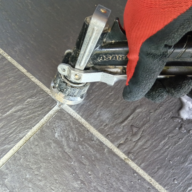 玄関の床にシロアリ駆除剤を注入する様子