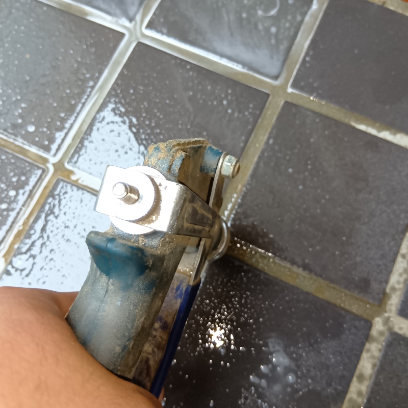 玄関の床にシロアリ駆除剤を注入する様子