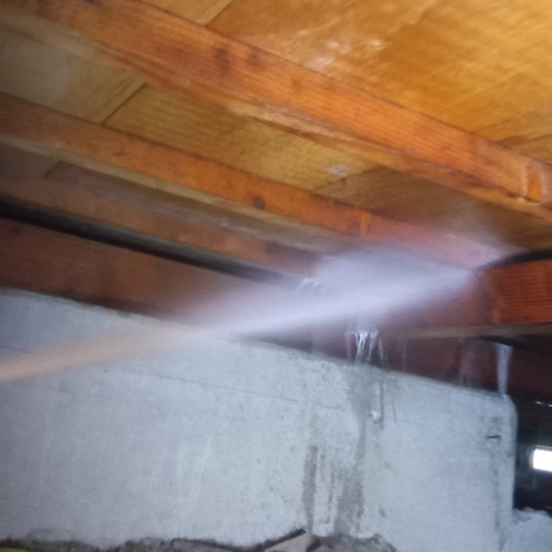 床下の木材にシロアリ駆除剤を散布する様子