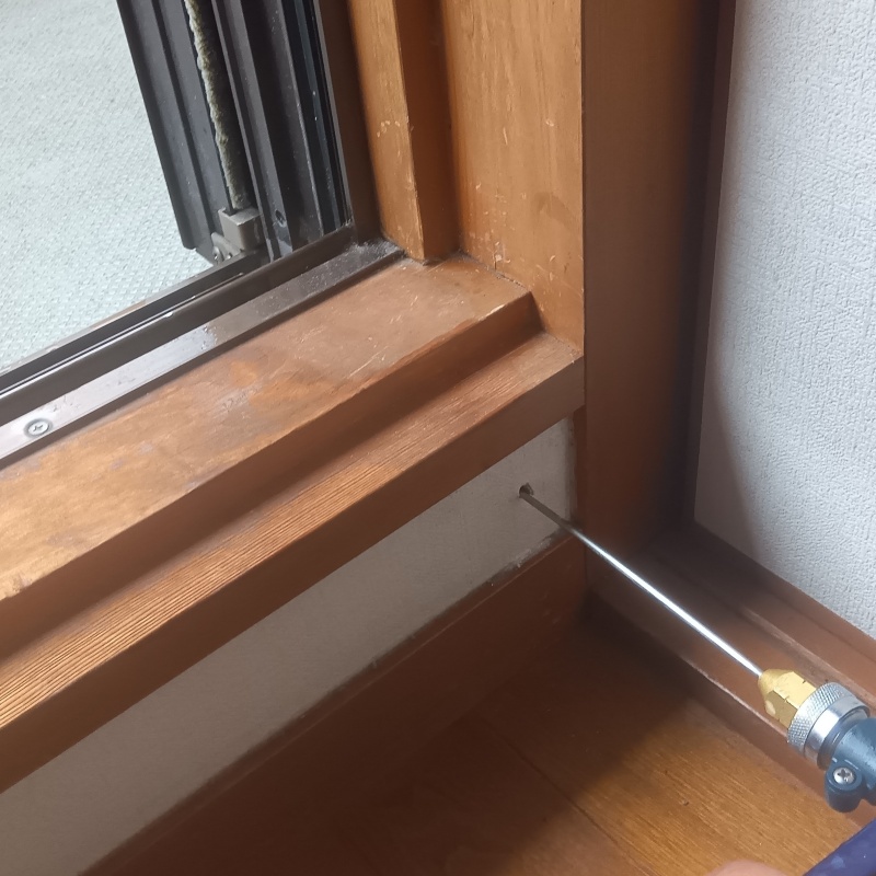 廊下の壁にシロアリ駆除剤を注入する様子