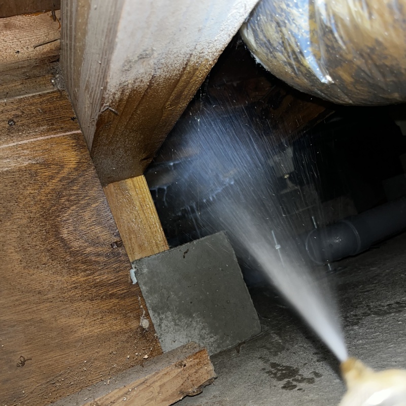 床下の木材にシロアリ駆除剤を散布する様子