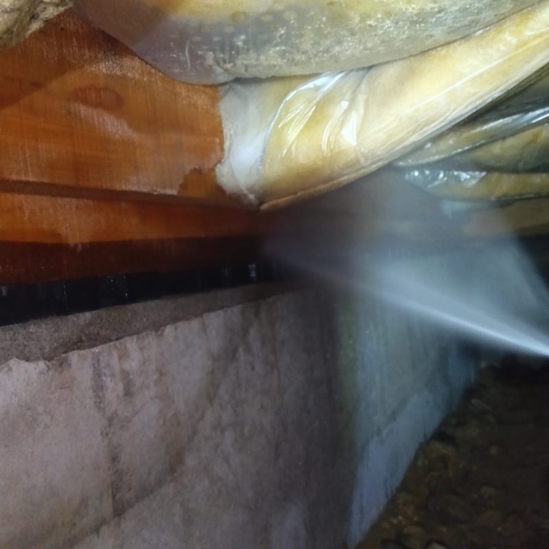 床下の木材と断熱材に防蟻剤を散布する様子