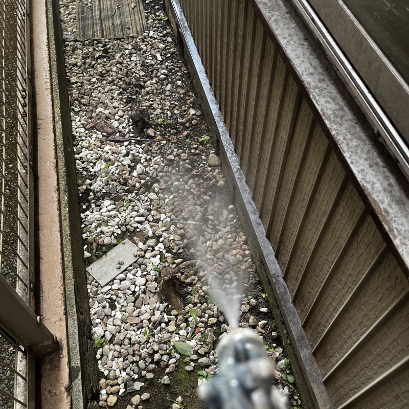 建物裏の土壌にシロアリ駆除剤を散布