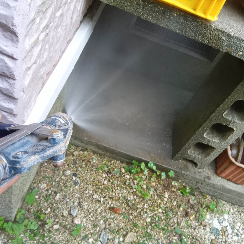 屋外の地面にシロアリ駆除剤を散布